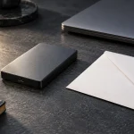 Disque externe et enveloppe fermée sur un bureau, évoquant la préparation de données personnelles.